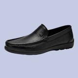 A pair of the deep onyx black Men's Full-Grain Leather Dress Slip-On Loafers